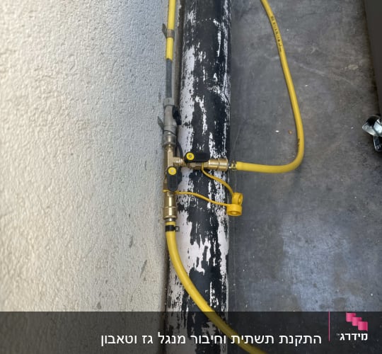 צינור גז צהוב מחובר לשסתום על צינור שחור